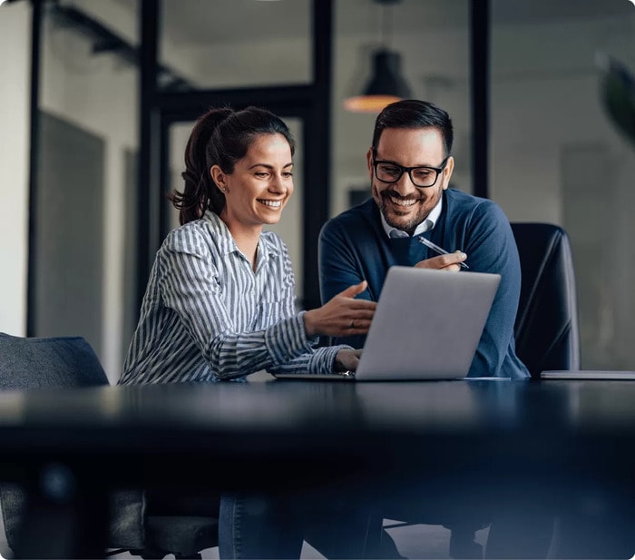 happy office employees working on laptop together