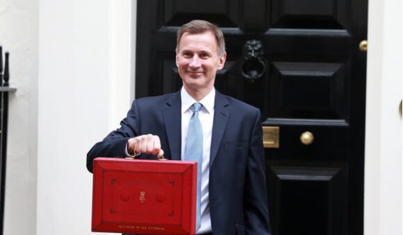 politician outside downing street holding red briefcase