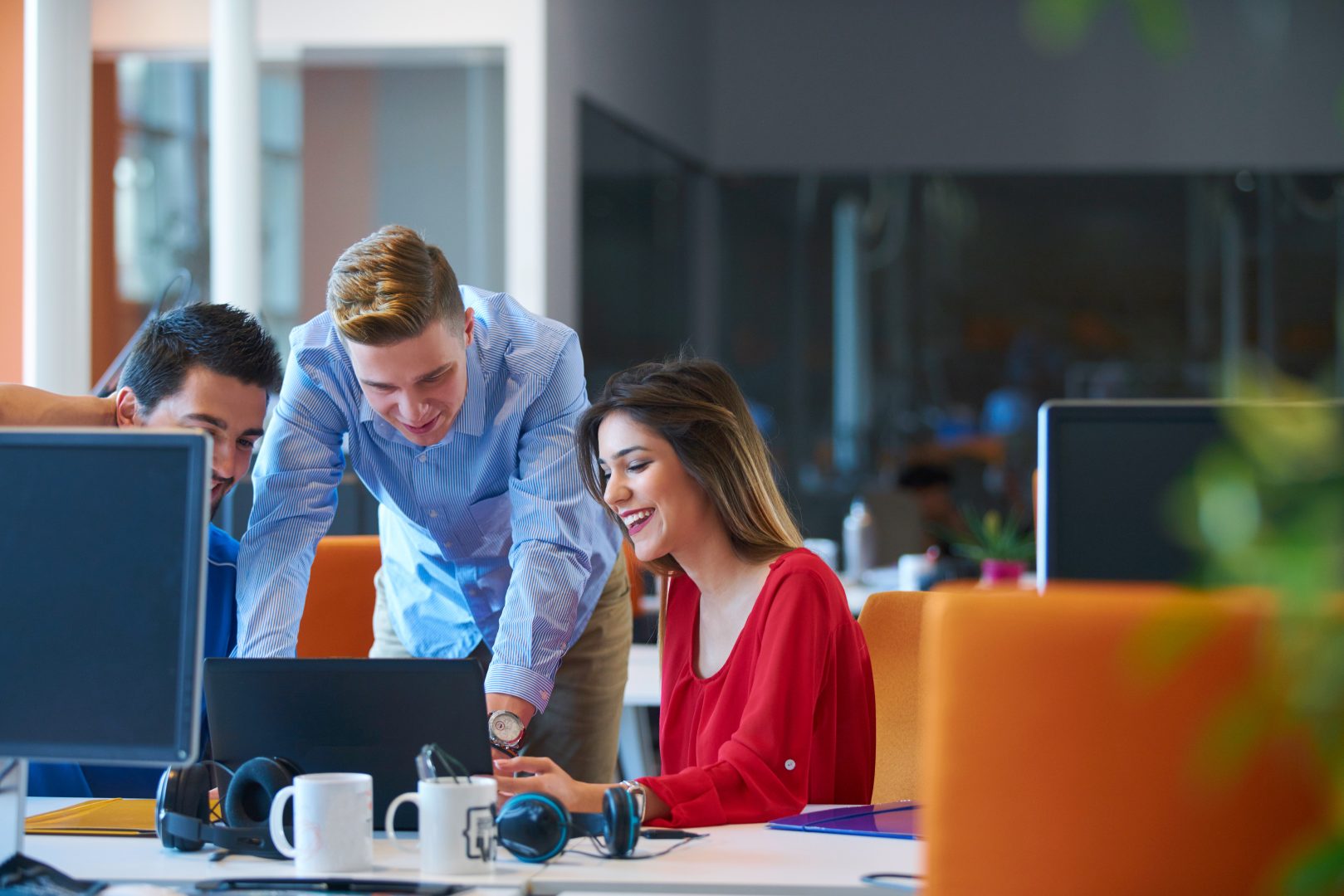 Group of three working at a desk with PC